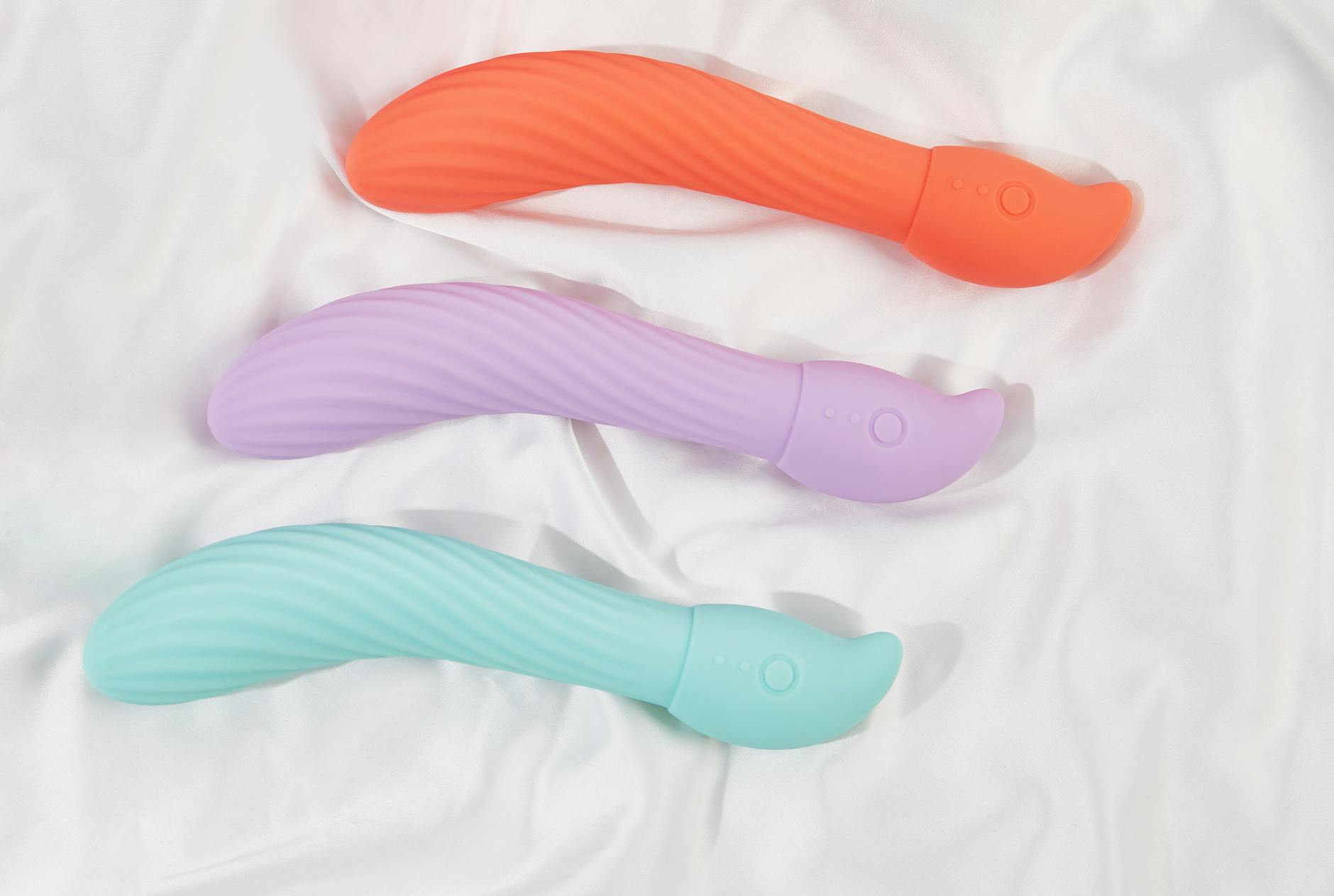 A young couple standing together indoors, holding a blue vibrator, symbolizing modern intimacy and connection.
