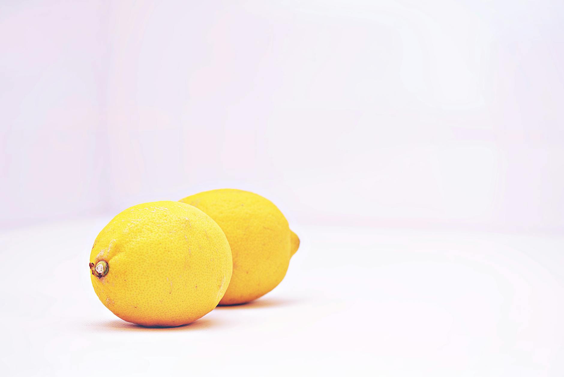 Bright yellow lemons against a white background, symbolizing slow, gradual build and freshness
