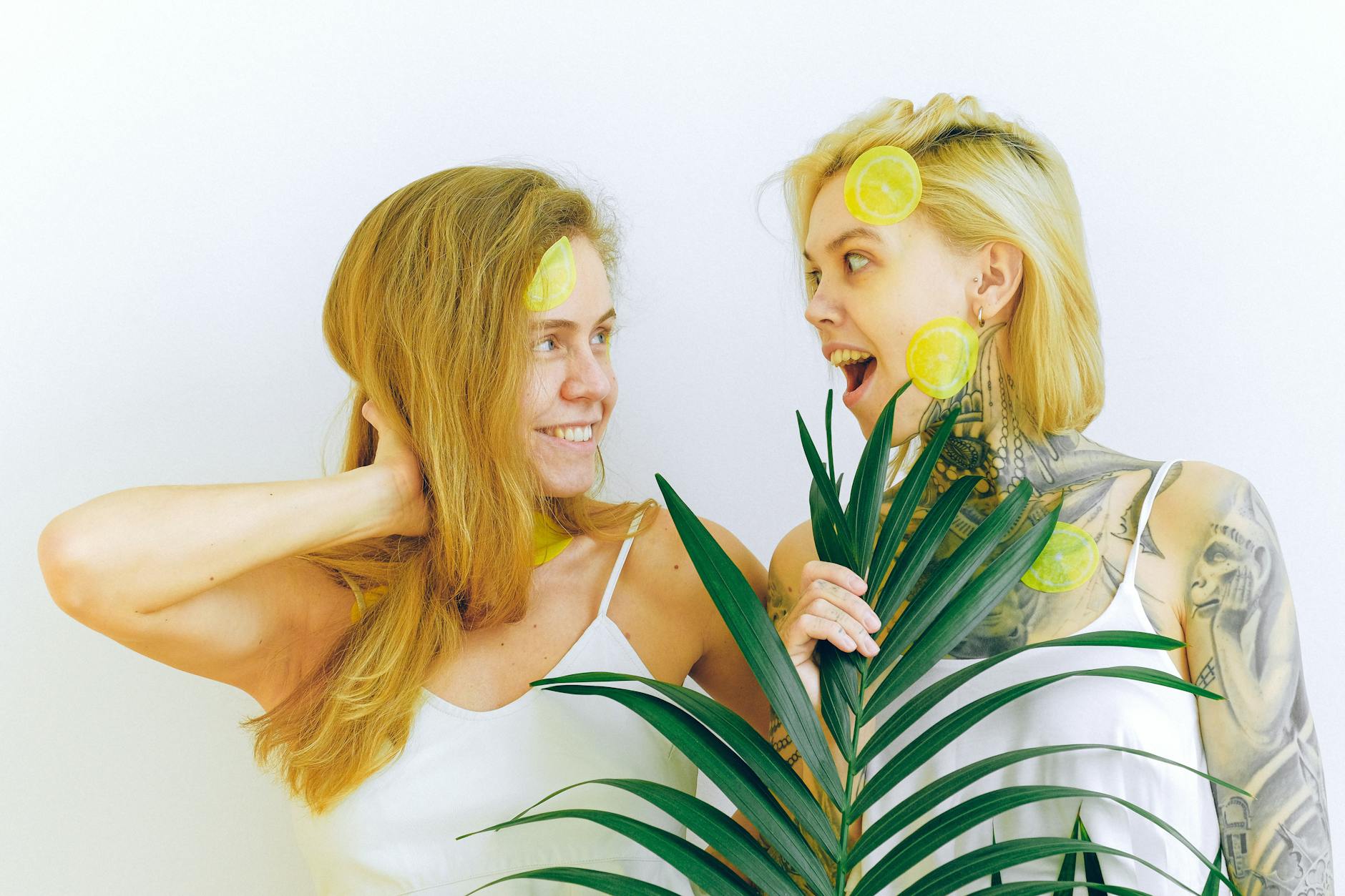 Two women laughing together outdoors with lemons and plants, expressing joy and comfort