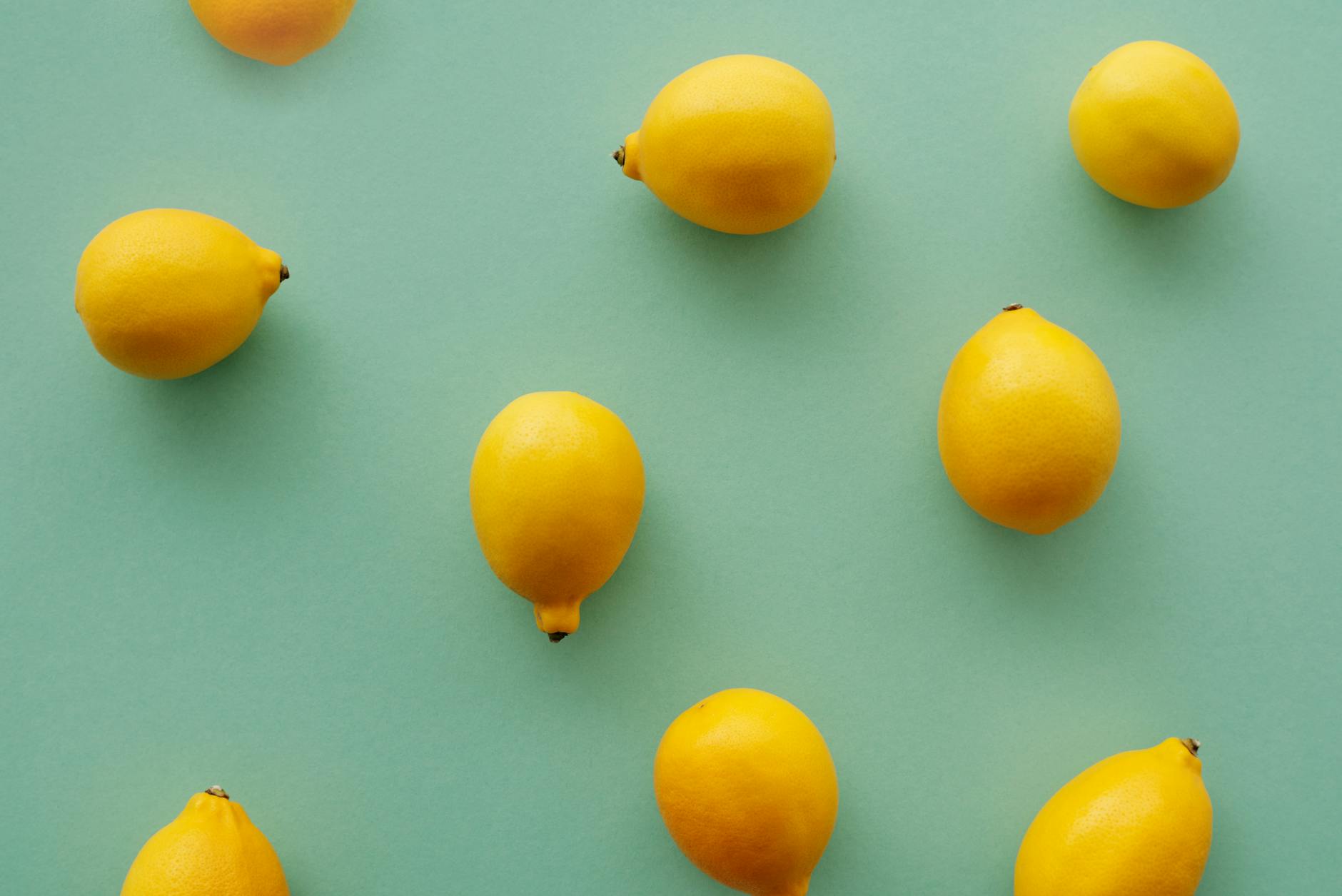 Bright yellow lemons arranged on a pastel green background, symbolizing renewal and freshness after life transitions.
