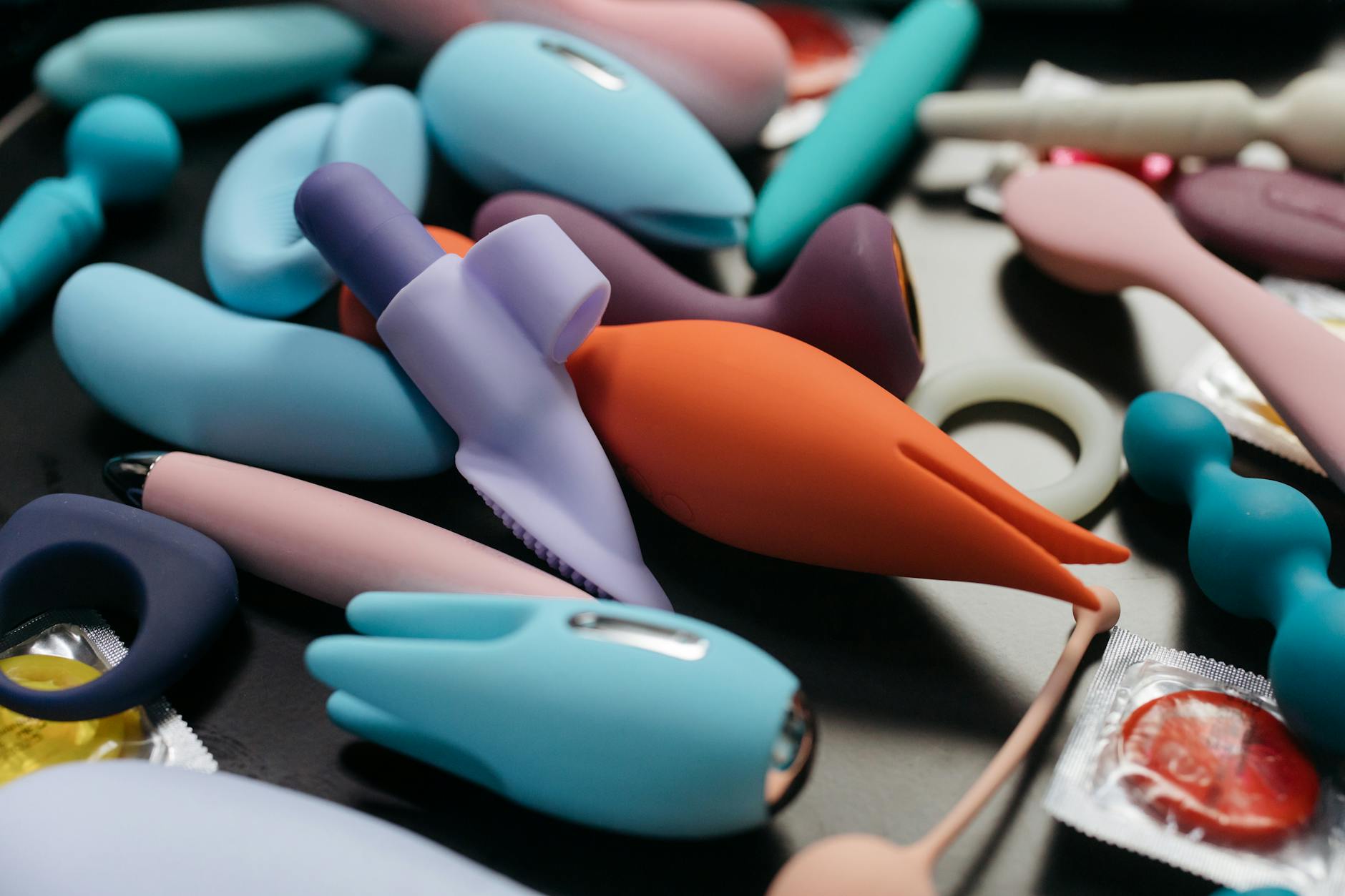 A woman holding two colorful clitoral vibrators, exploring pleasure options with intention