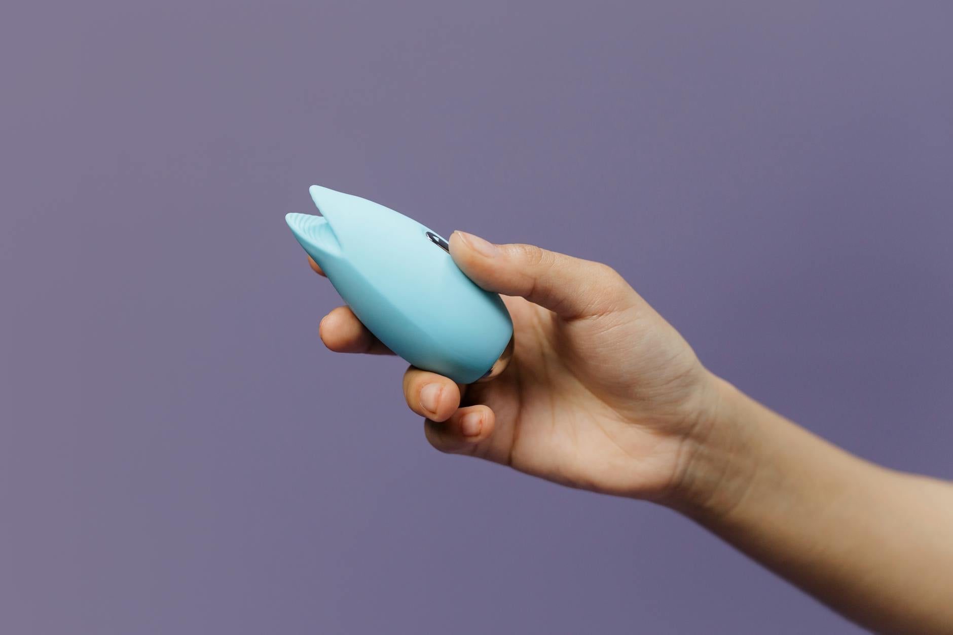 A lemon-colored clitoral vibrator held in hand, promoting sexual wellness and sensation recovery