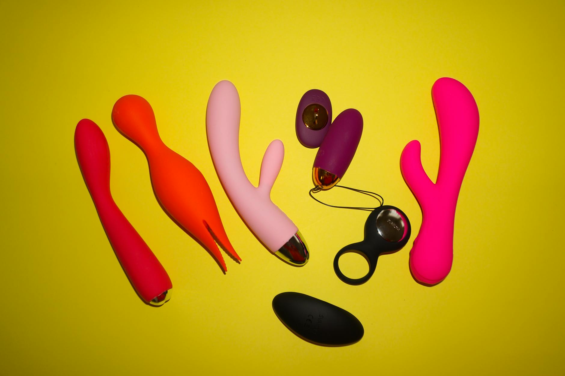 A young couple standing together indoors, holding a blue vibrator, symbolizing modern intimacy.