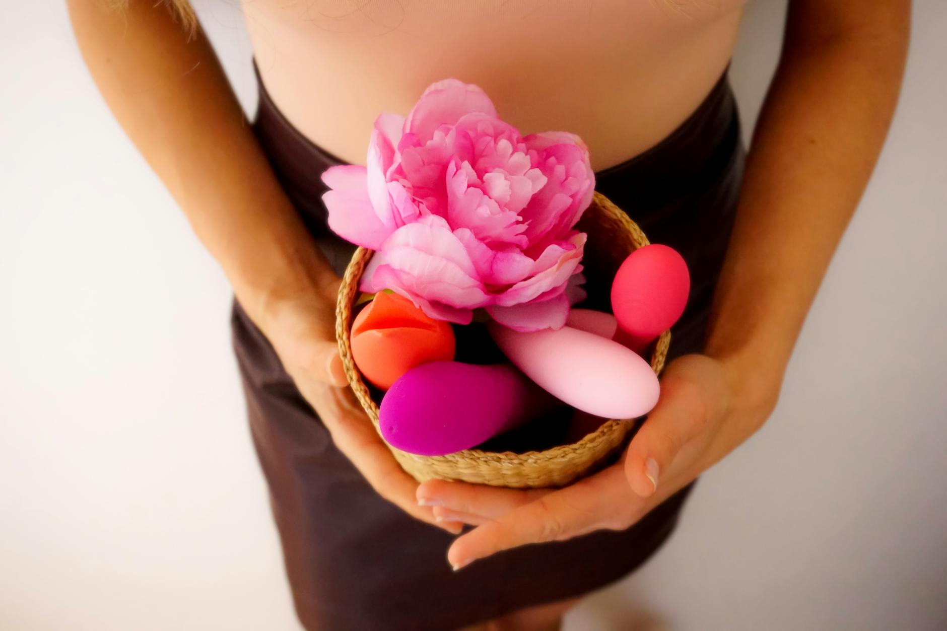 Woman holding two silicone vibrators, representing safe pleasure options for sensitive bodies